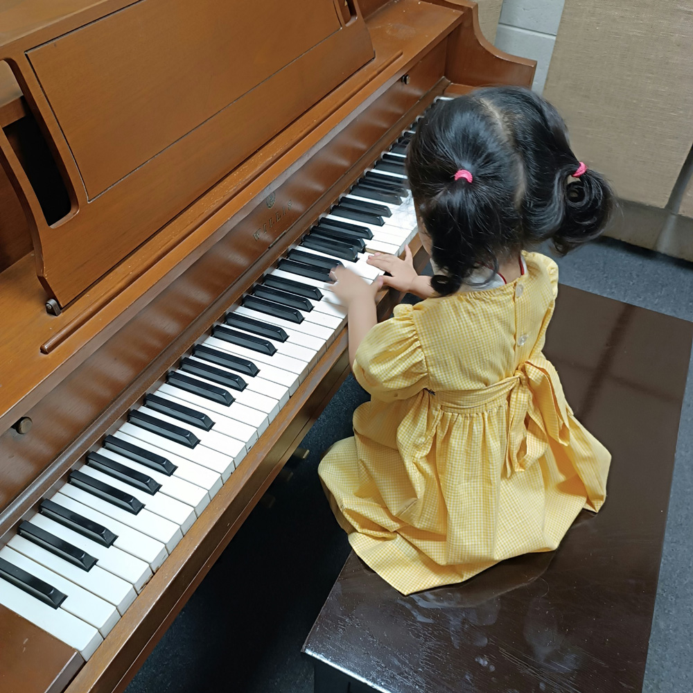 bebé tocando piano en clase de estimulación temprana musical en Cancún
