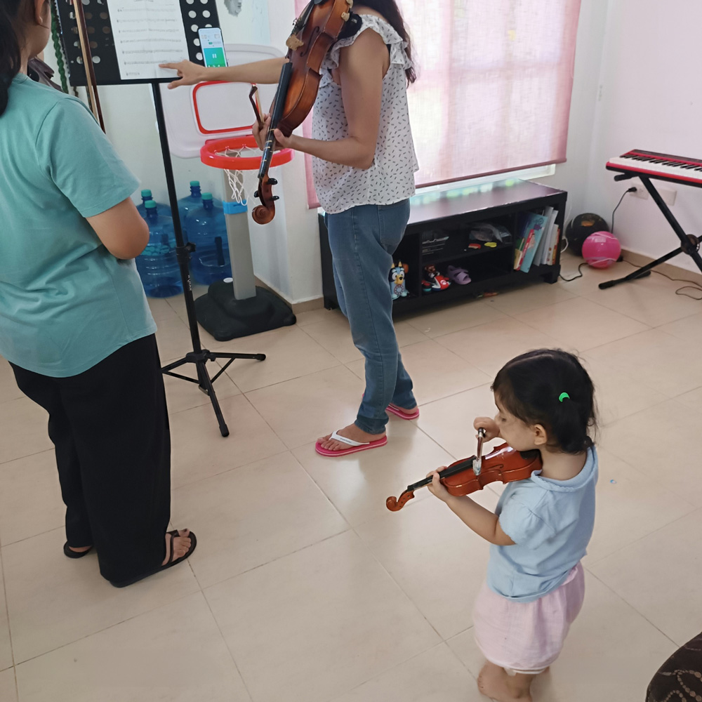 Bebé practicando su violín durante un ensayo de música, como parte de su rutina cotidiana de juego y aprendizaje.