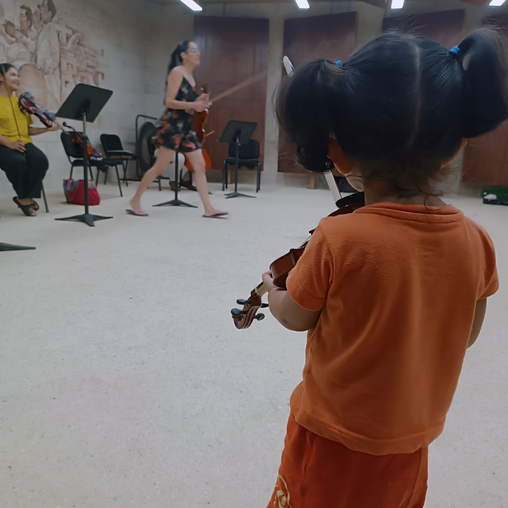 bebé explorando violín durante sesión musical en Cancún